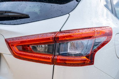 Modern beyaz bir arabanın arka lambasının ayrıntıları. Geceleri yeni sağ arka fren lambası