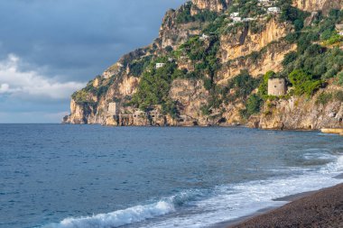 Arka planda eski bir kulesi olan Positano plajı, seyahat