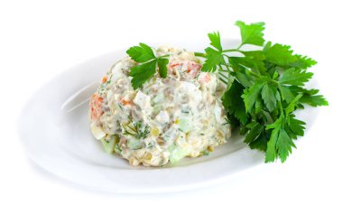 Çeşitli haşlanmış sebzelerin sirke salatası maydanozu beyaz tabakta siliyor.