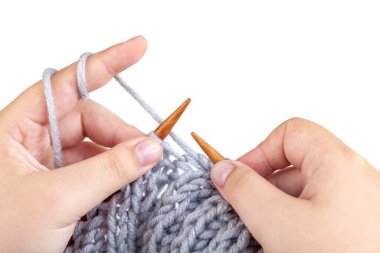 Beyaz arka planda gri yün ören kadın elleri, hobi