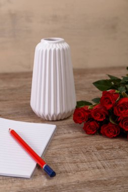 Not defteri ve kalem ile kırmızı gül. Tasarım seviyorum.