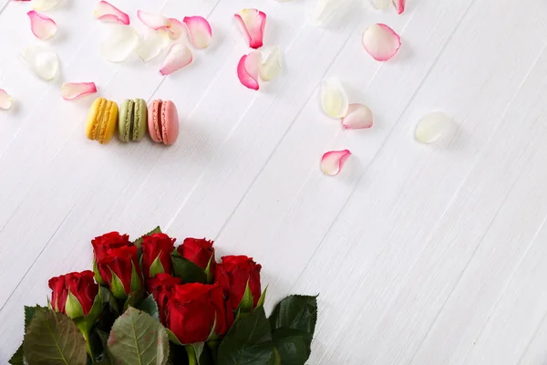Makronenkuchen mit einem Strauß roter Rosen. — Stockfoto