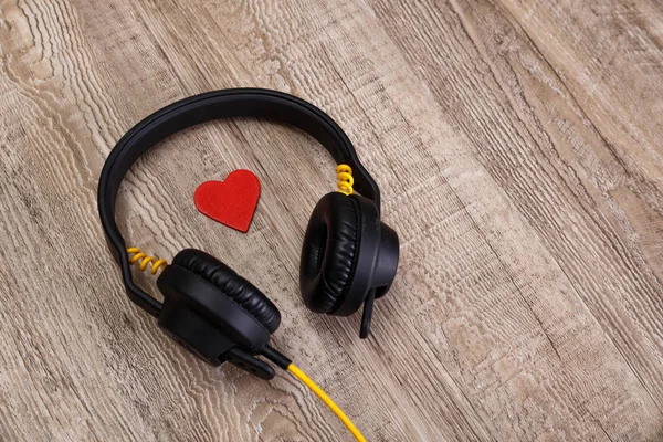 Headphones with red heart. Wooden background. — Stock Photo, Image