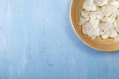 Mavi ahşap arka plan üzerinde beyaz gül yaprakları.