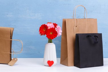 Mockup boş alışveriş torbaları. Gerbera çiçekleri.
