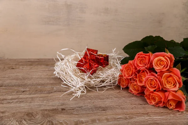 Růžové růže s dárkové krabičky na dřevěné pozadí. — Stock fotografie