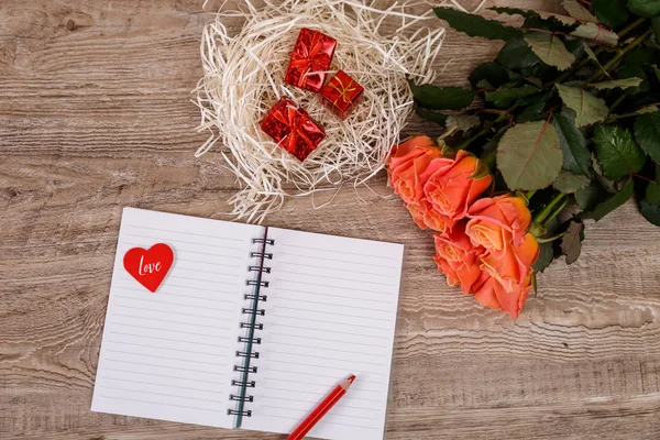 Pink roses with heart, gift boxes and notebook. — Stock Photo, Image