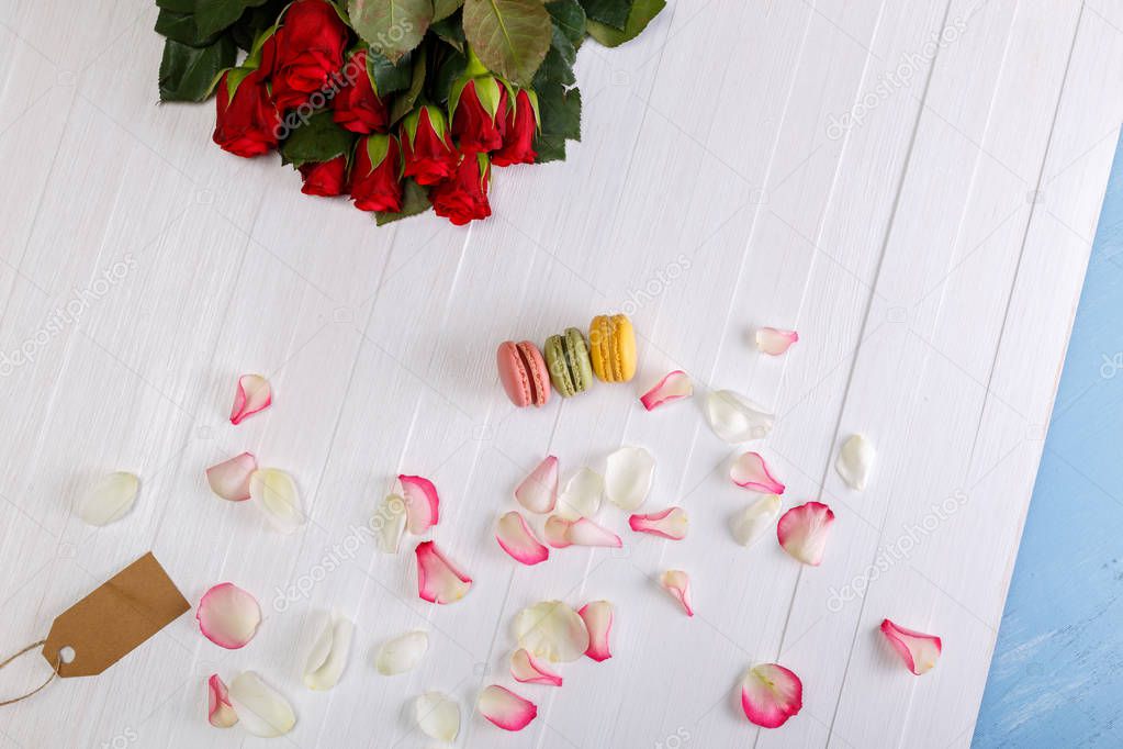 Macaroon cakes with bouquet of red roses.