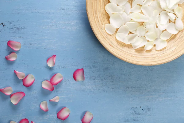 Mavi ahşap zemin üzerine gül yaprakları.