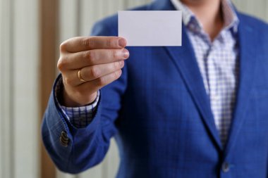 Ziyaret veya iş kartı tutan işadamı.