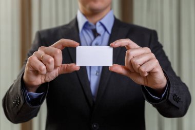 Ziyaret veya iş kartı tutan işadamı.