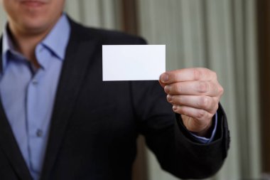 Ziyaret veya iş kartı tutan işadamı.