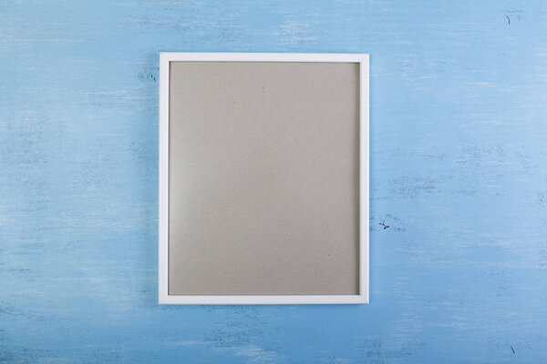 Blank photo frame on blue wood background.