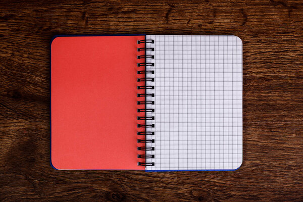 Notepad on the wooden rustic desk. Mockup.