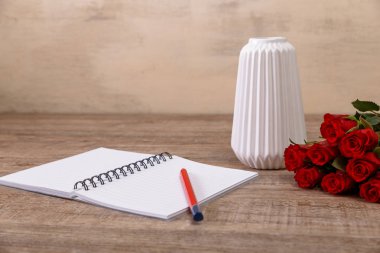 Not defteri ve kalem ile kırmızı gül. Tasarım seviyorum.