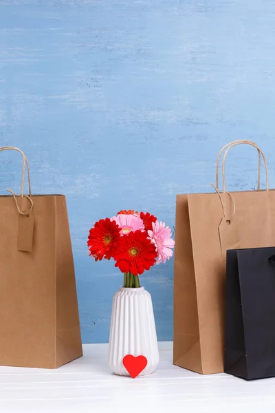 Burla de las bolsas de la compra en blanco. Flores de Gerberas . —  Fotos de Stock