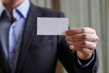 Ziyaret veya iş kartı tutan işadamı.