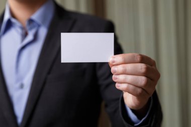 Ziyaret veya iş kartı tutan işadamı.