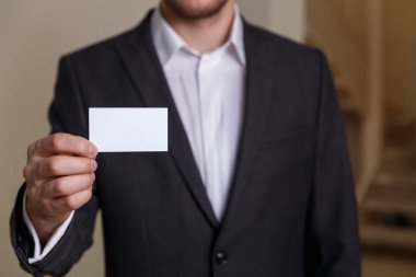 Ziyaret veya iş kartı tutan işadamı.