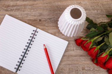 Not defteri ve kalem ile kırmızı gül. Tasarım seviyorum.