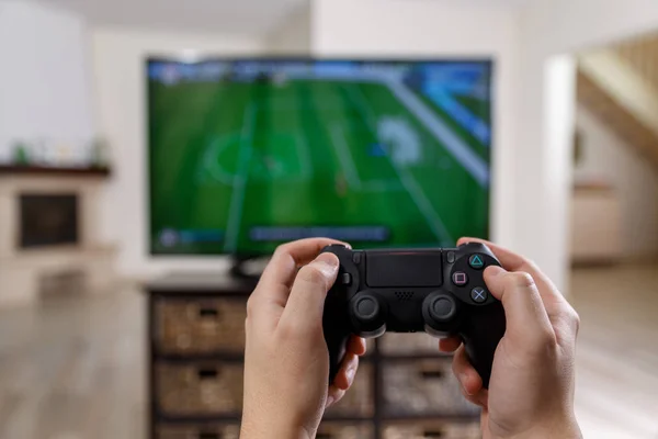 Un uomo che gioca ai videogiochi. Mani che tengono il controller . — Foto Stock