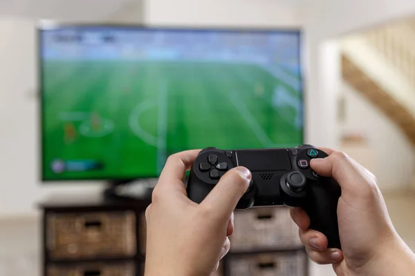 Man spelar videospel. Händerna håller handkontrollen. — Stockfoto