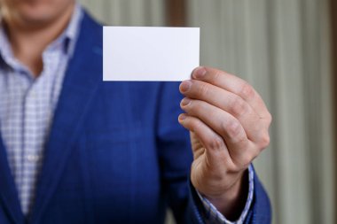 Ziyaret veya iş kartı tutan işadamı.