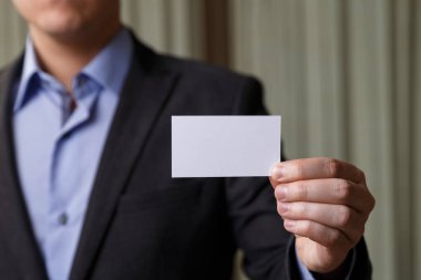 Ziyaret veya iş kartı tutan işadamı.