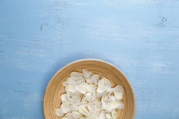 Pétalos de rosas blancas sobre fondo de madera azul . — Foto de Stock