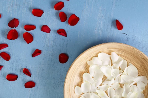 Mavi ahşap zemin üzerine gül yaprakları.