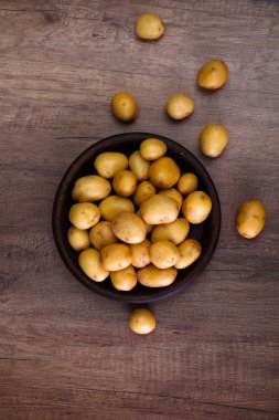 Ahşap masa üzerinde rustik bir tabak patates.