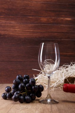 Şarap şişesi. Kadehinin karanlık üzüm şubesi ile.