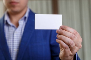 Ziyaret veya iş kartı tutan işadamı.