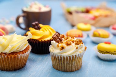 Buttercream ve macaroons ile cupcakes.