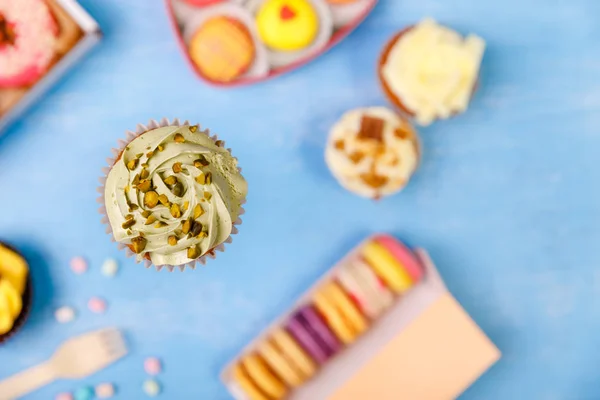 Cupcake mit Pistaziencreme, Donuts, Makronen. — Stockfoto
