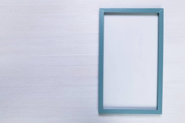 Beyaz ahşap zemin üzerinde boş fotoğraf çerçevesi.