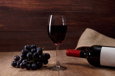 Kırmızı şarap. Bardağı üzüm şubesi ile.