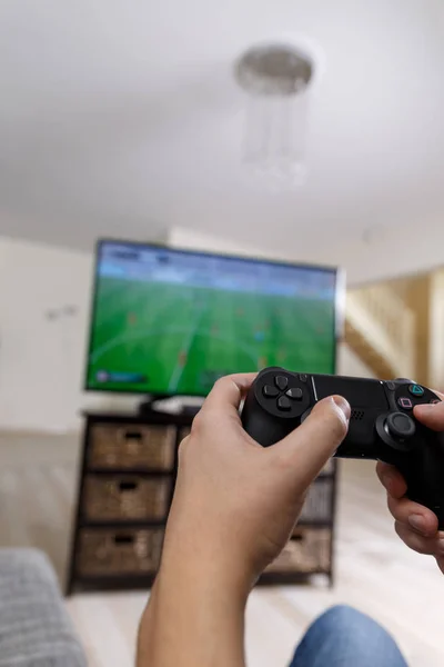 Man playing video game. Hands holding controller.