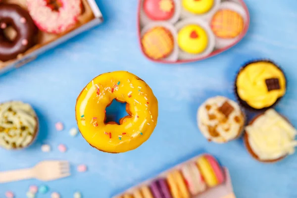 Помаранчевий глазурований пончик, кекси та макарони . — стокове фото