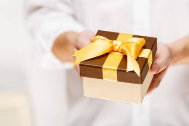 Bir hediye kutusu kurdele ile holding erkek eller.