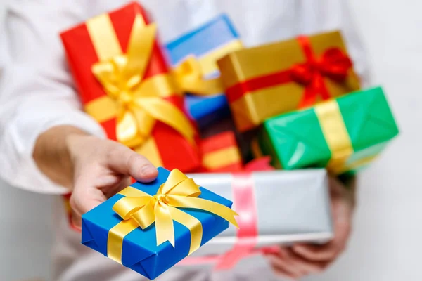 Male hands holding a gift boxes with ribbons.