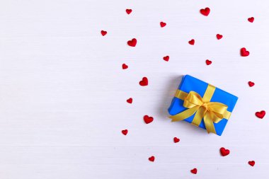 Hediye kutusu ile kırmızı kalpler. Mavi geçerli paketin.