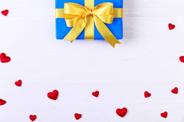 Hediye kutusu ile kırmızı kalpler. Mavi geçerli paketin.