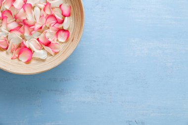 Mavi ahşap zemin üzerine gül yaprakları.