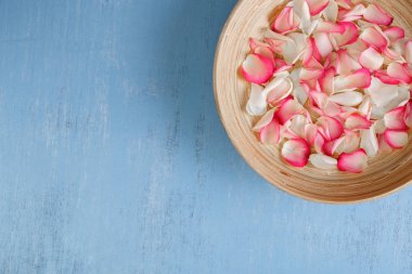 Mavi ahşap zemin üzerine gül yaprakları.