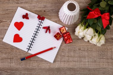 Kalpler, hediye kutuları ve defter ile beyaz güller.