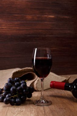 Kırmızı şarap. Bardağı üzüm şubesi ile.
