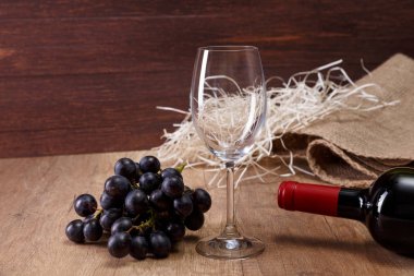 Şarap şişesi. Kadehinin karanlık üzüm şubesi ile.