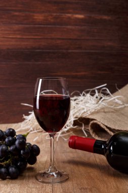 Kırmızı şarap. Bardağı üzüm şubesi ile.
