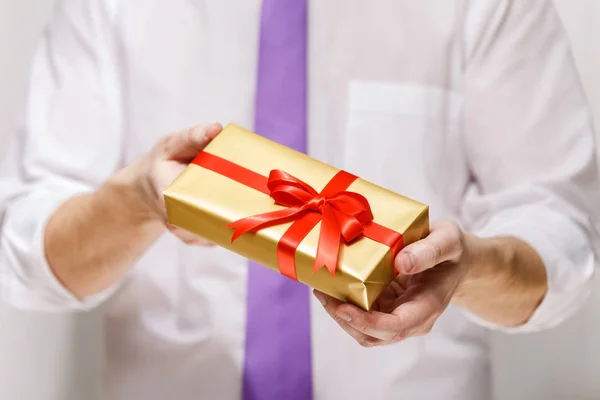 Male hands holding a gift box with ribbon. — Stock Photo, Image